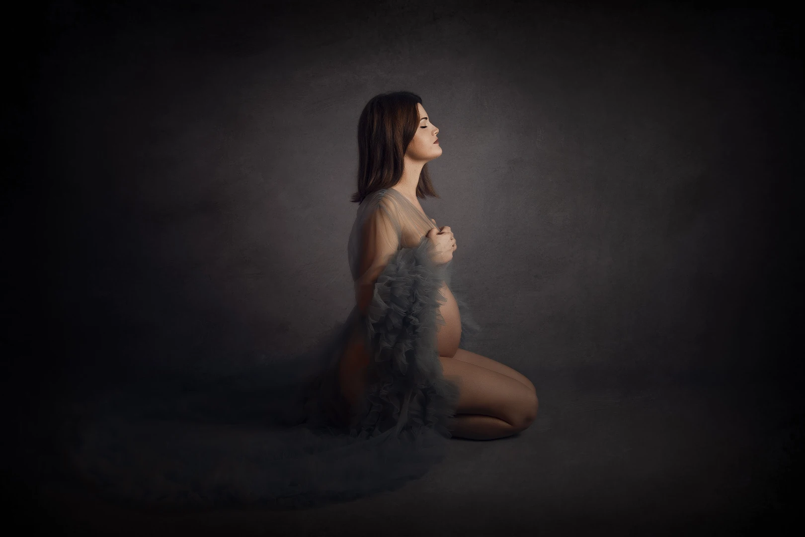 Fotografía de embarazada en fondo oscuro